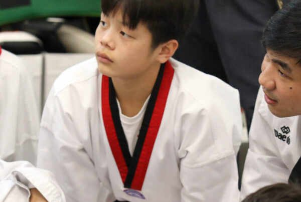 Group of Endurance Taekwondo students listening attentively to instructor during class