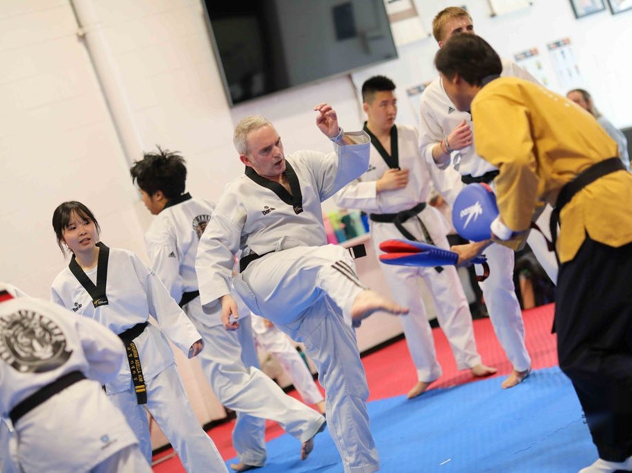 Adult black belt front kick at an Endurance Taekwondo black belt test