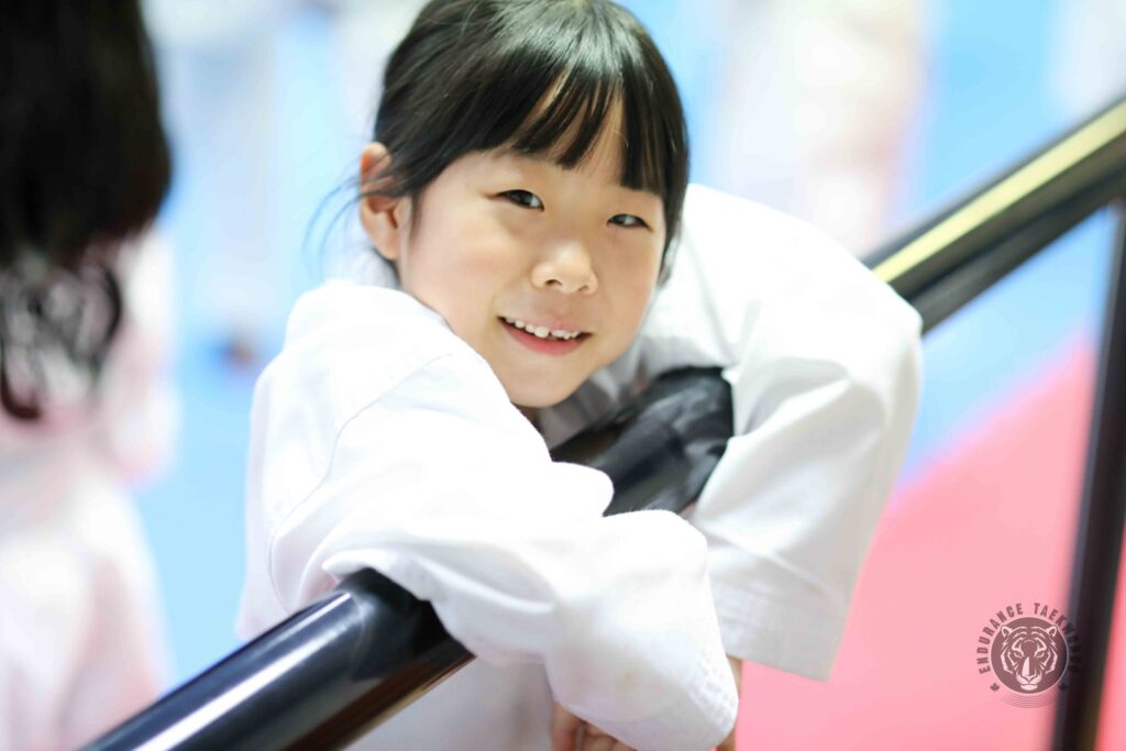 A young yellow belt student smiling at taekwondo camp